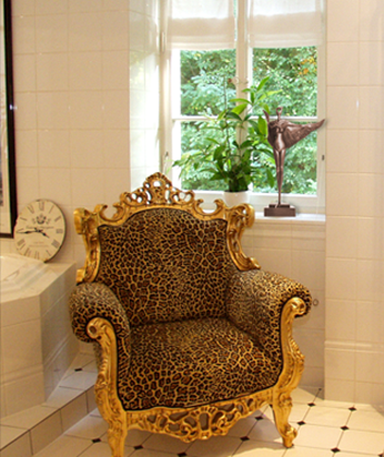 Barocksessel mit Leopardenmuster vor Sprossenenster mit surrealisterscher Bronzefigur