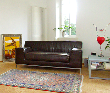 Bild: Schwarzes Ledersofa  mit Bild: Das Geheimnis des surrealistischen Engels als Bote der Abenddämmerung von Erich Kraft